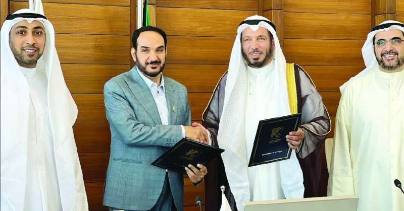 عبدالله المعتوق ونواف المطيري عقب توقيع الاتفاقية