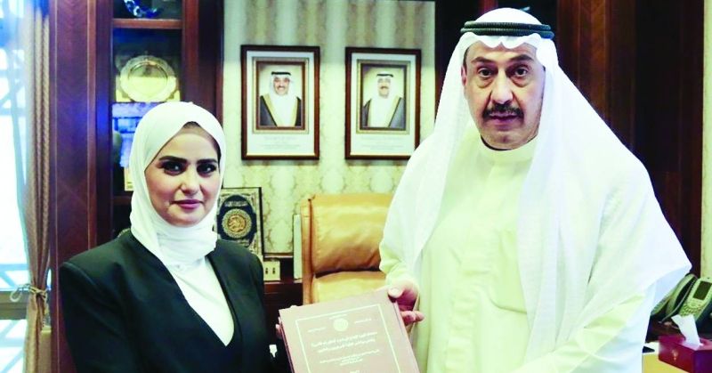 فيصل الحمود مُتلقّياً إهداء المطيري