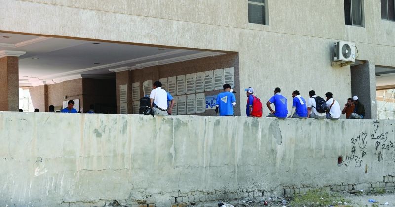 عمال ينتظرون خارج العمارة عودة التيار (تصوير سعود سالم)