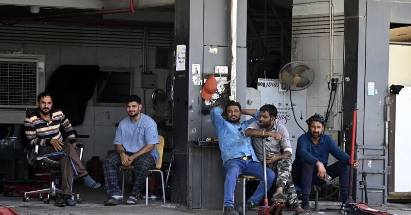 عمال في استراحة بعد انقطاع الكهرباء في الشويخ الصناعية الأسبوع الماضي
